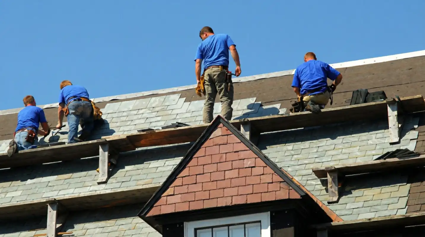 Roof replacement in progress with a team of professional contractors installing new shingles on a residential home in Rochester, NY